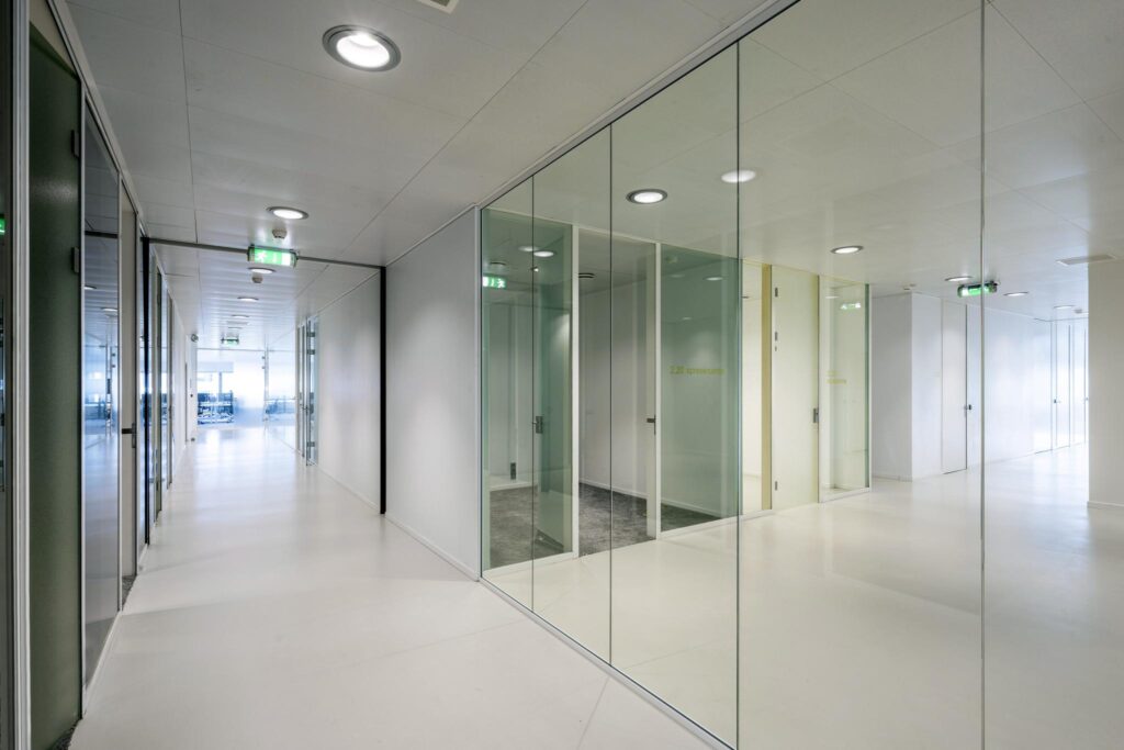 Modern office corridor with glass walls and meeting rooms at Prof. E.M. Meijerslaan.